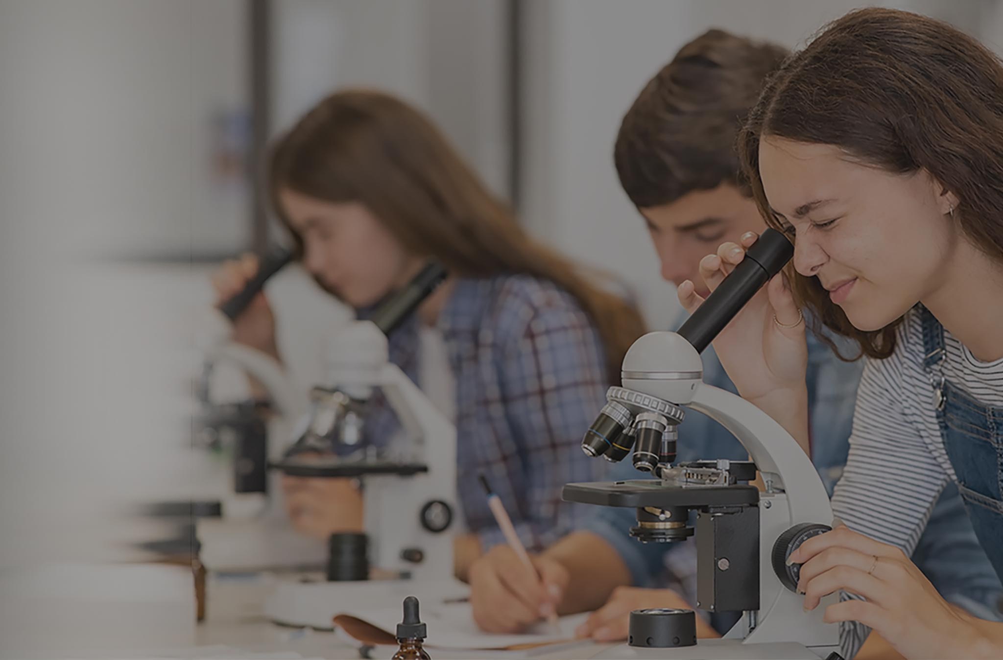 Girl in science class using a microscope