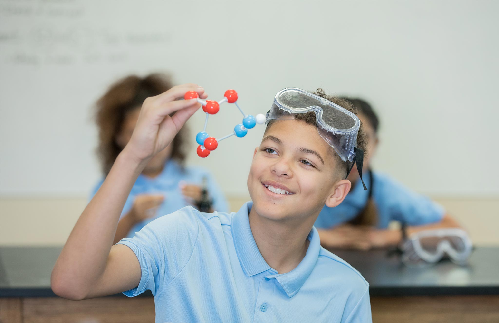 Boy holding model in science class
